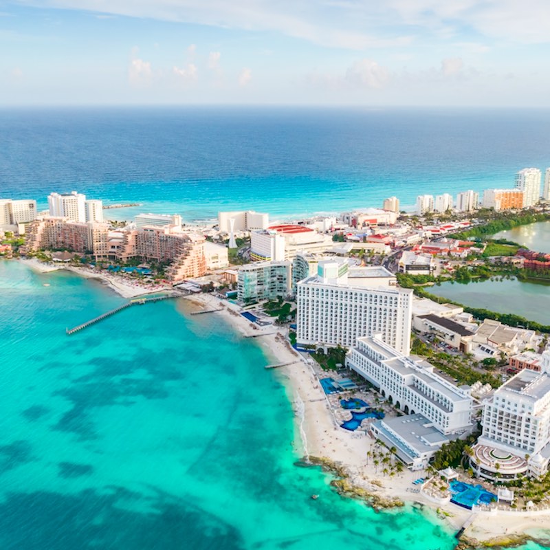 Aerial panoramic view of Cancun beach and city hotel zone in Mexico. Caribbean coast landscape of Mexican resort with beach Playa Caracol and Kukulcan road.