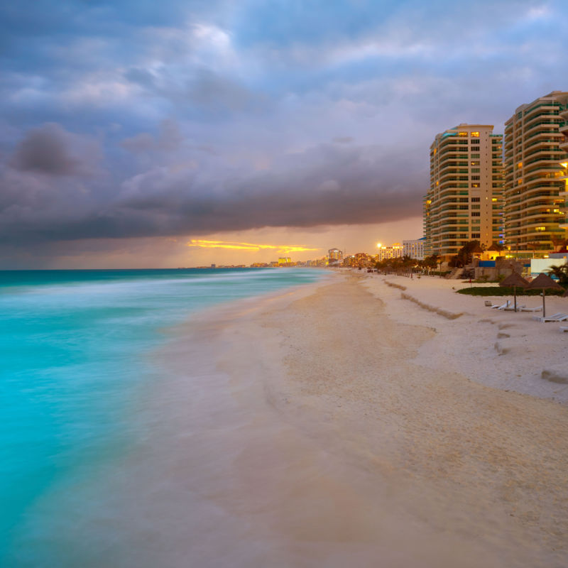 Sunset in a Cancun beach with a resort in the background 