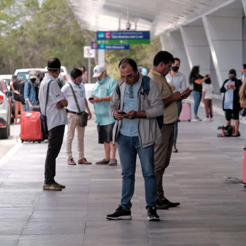 Passengers outside of Cancun airport waiting for a taxi