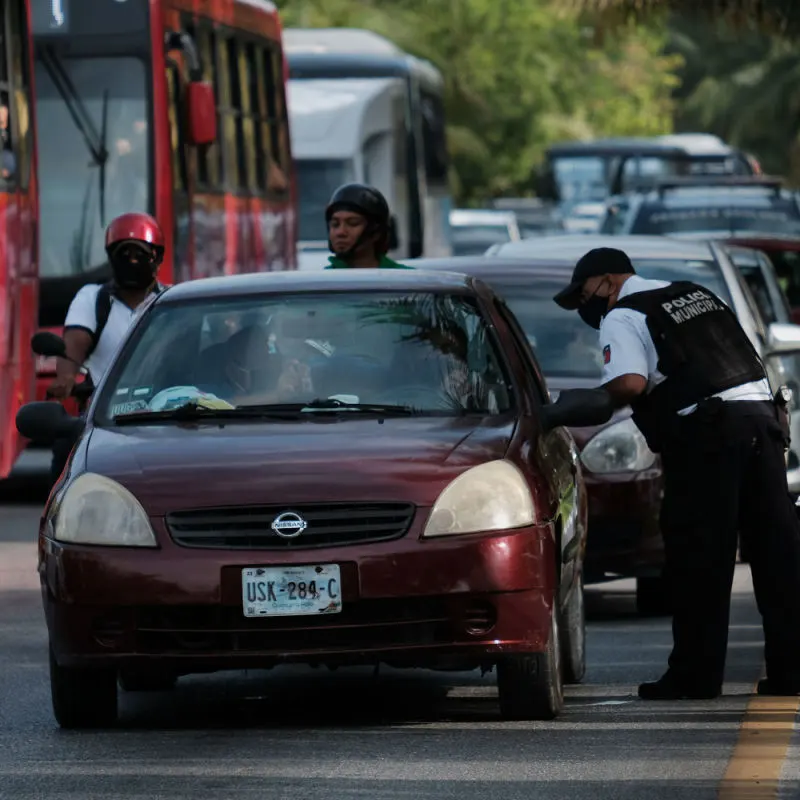 A police officer conducting a spot check on a Cancun car