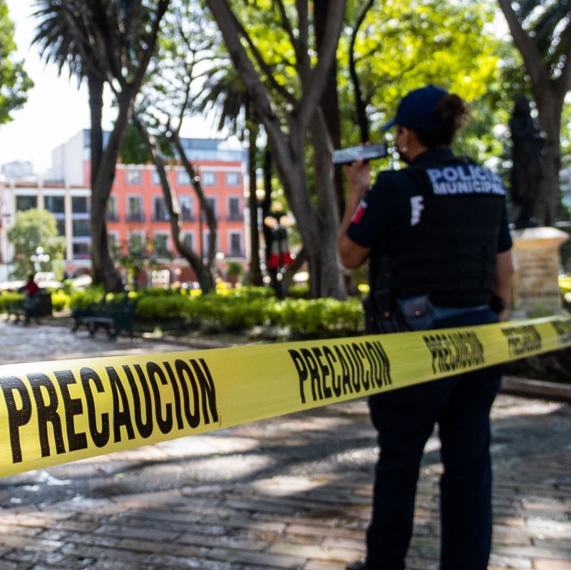 Crime scene tape in Mexico with female officer on guard