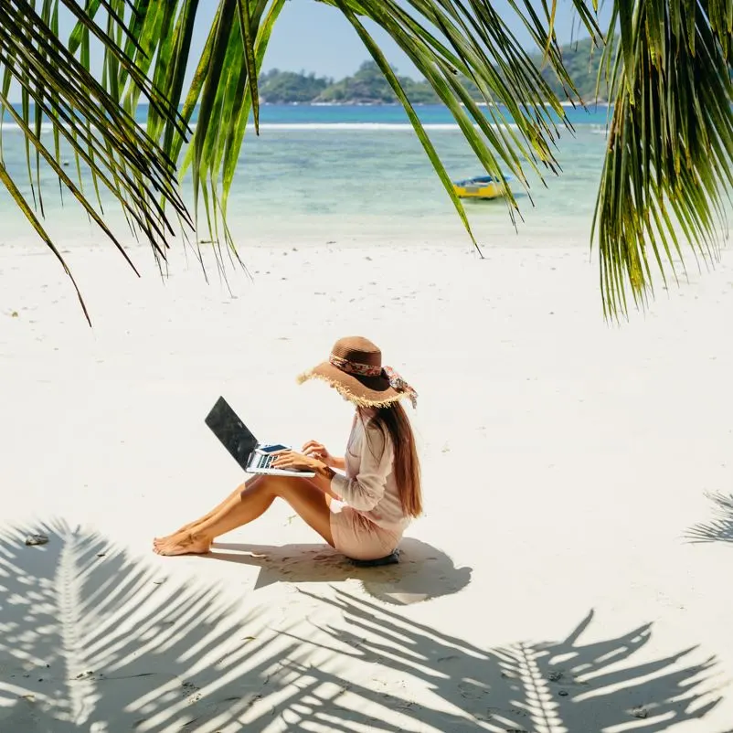 woman on her laptop on beach