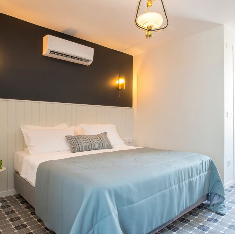 hotel room with air conditioning unit above the bed