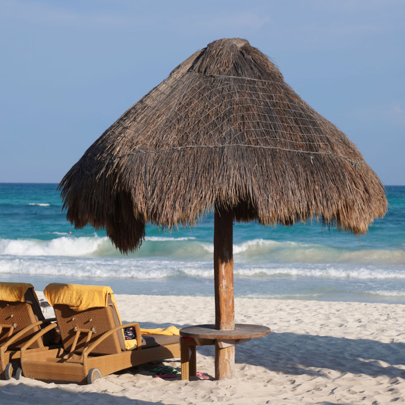A sunshade made of straw on a white sand beach in the Riviera Maya 