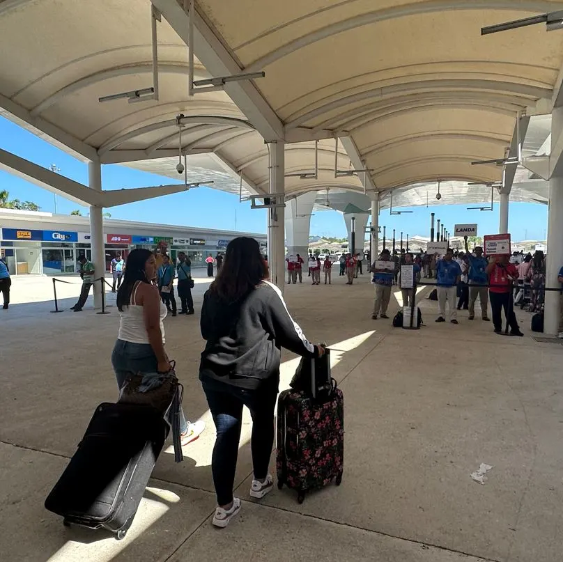 Travelers walking out of Cancun airport towards ground transportation