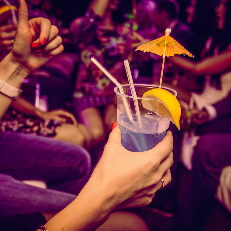 Partygoers holding drinks in a Tulum nightclub