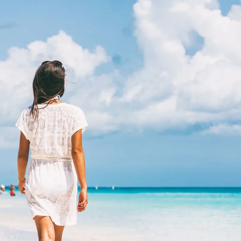 Woman Walking on a White Sand Beachh