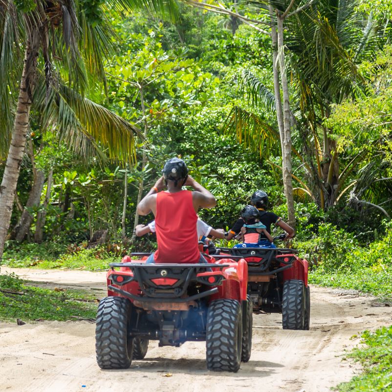 ATV tour group driving through a jungle path