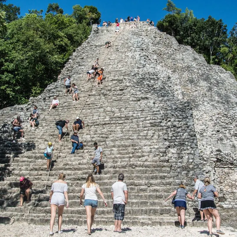 Coba mexico tourists looking at pyramid