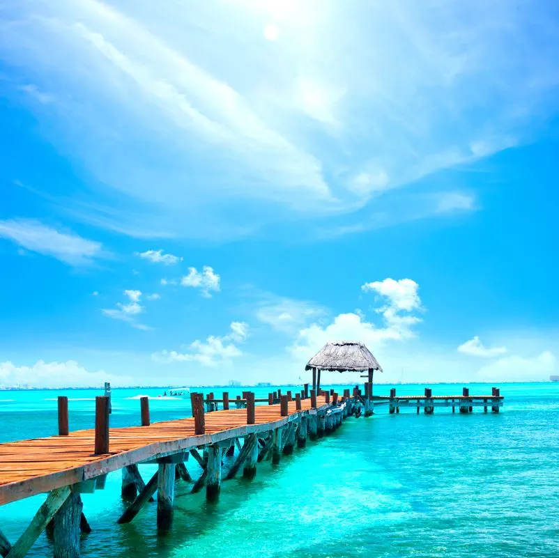 Pier stretching into the Caribbean sea with a small hut at the of it