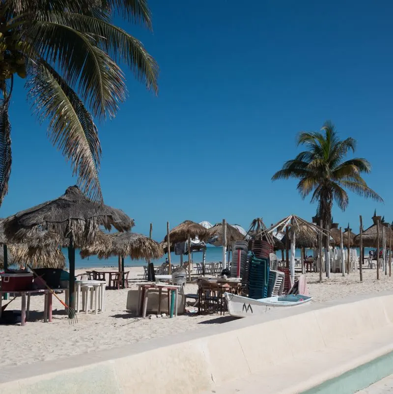 The progreso beachfront with sun loungers and palm sun shades
