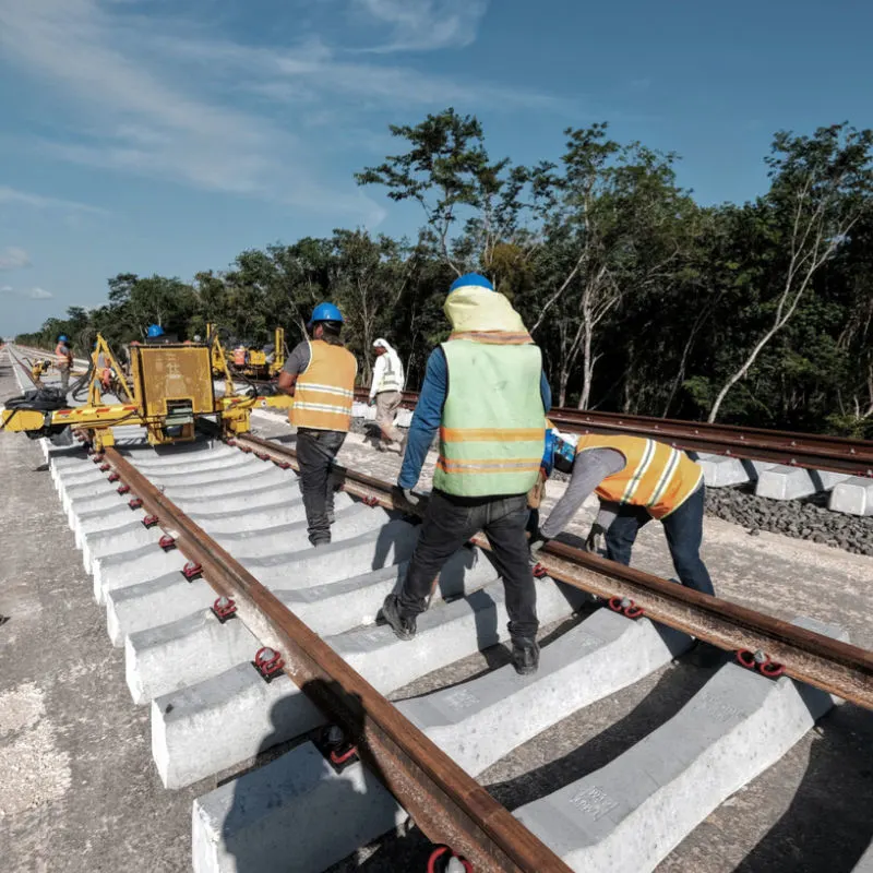 Construction workers laying down tracks for the Maya Train