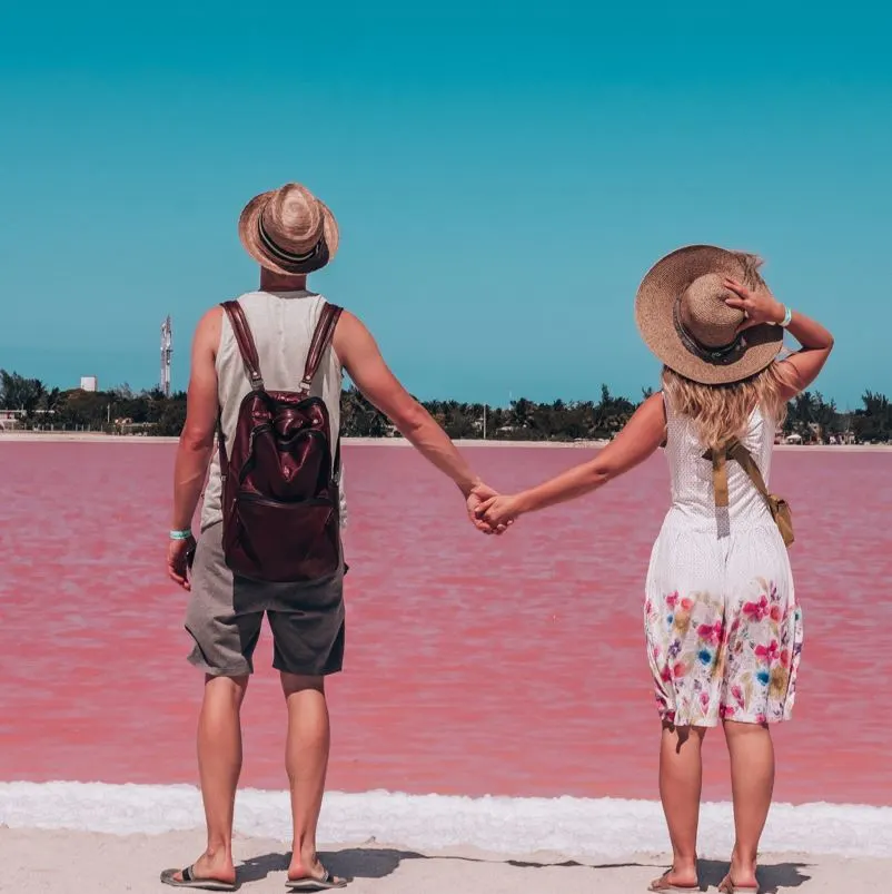 Young couple looking at las coloradas lake in mexico