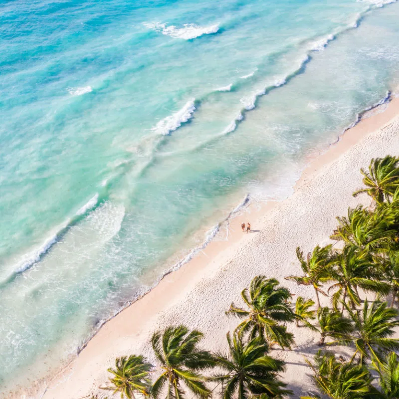 A couple walks by the beautiful beach in Cancun