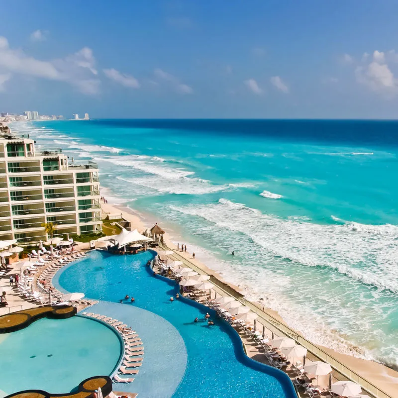 A resort pool and white sand beach in Cancun