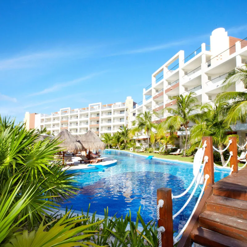 A Cancun resort with a pool and greenery 