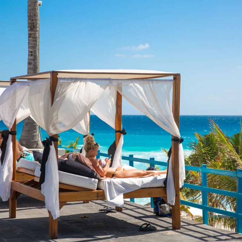 Travelers seeking shade from the sun in Cancun 