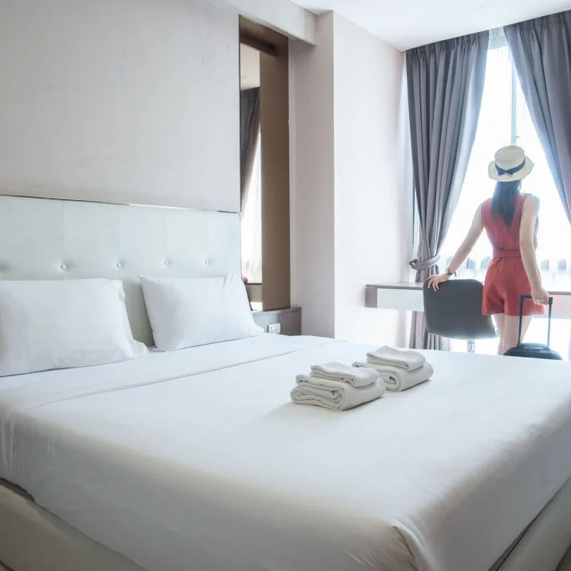 A guest in a large resort room looking out the window 