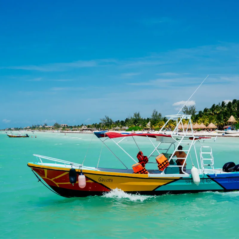 Boat by the beach in Holbox, on top of the clear water