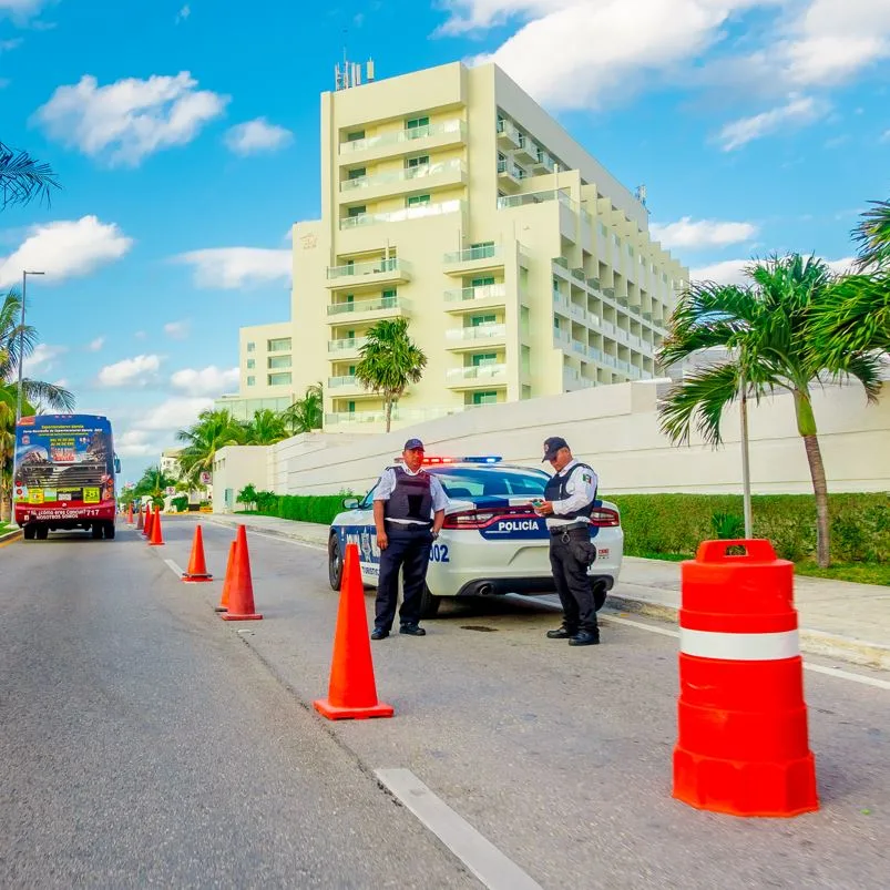 Cancun Police Standing Outside of Their Vehicle