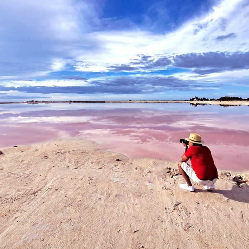 man taking picture of pink lagoon