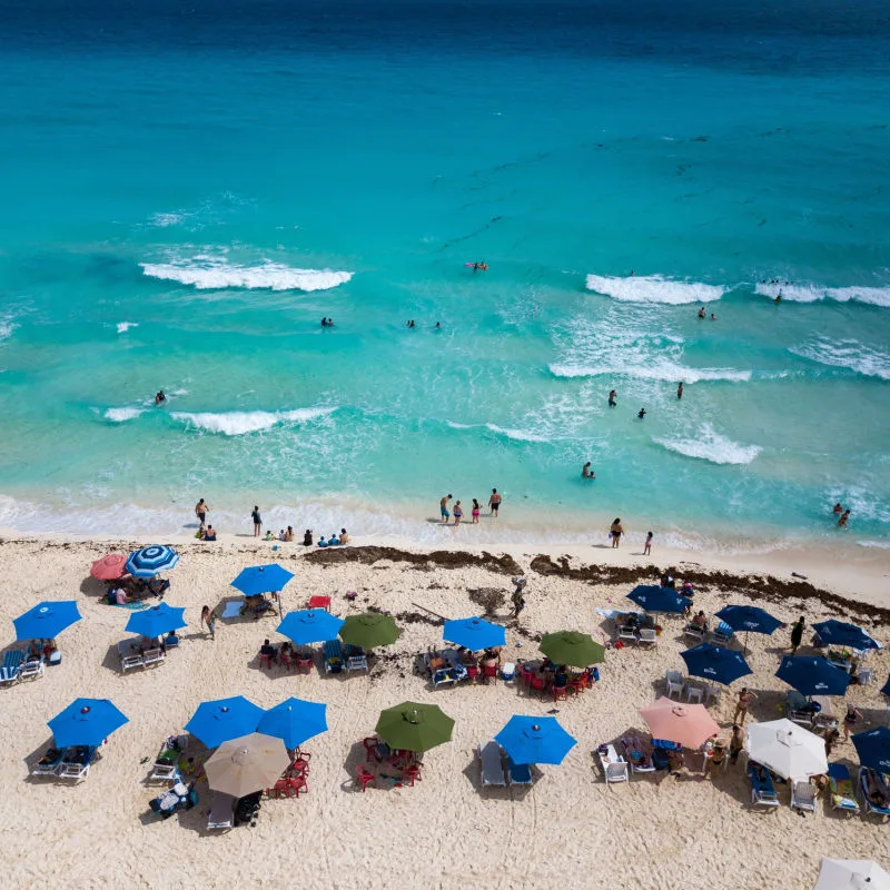 Aerial view of a beautiful beach in Cancun with travelers and blue water