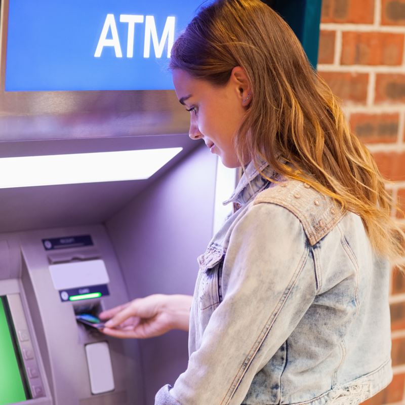 Woman using ATM machine to withdraw cash