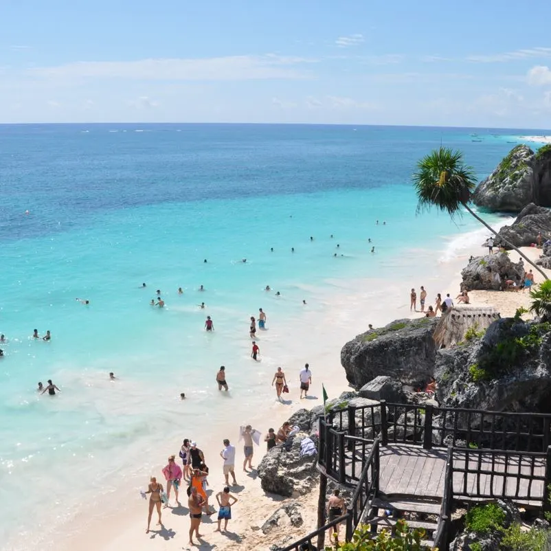 A beach in tulum with swimmers enjoying the water