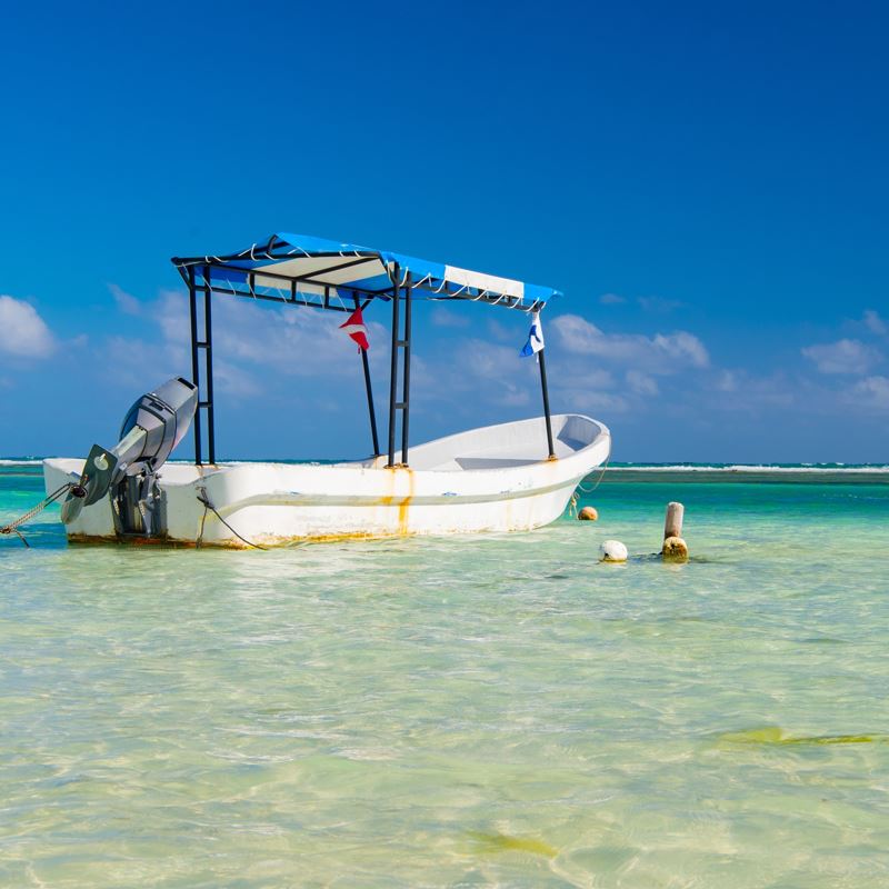 A small tourist boat in shallow water on Holbox island