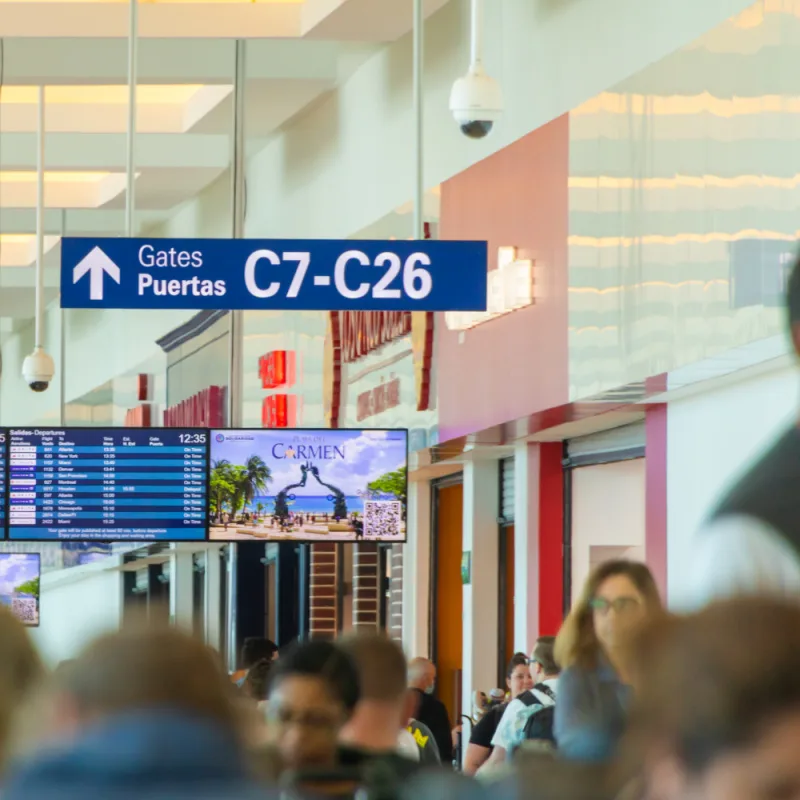 Tourists Walking Through Cancun International Airport to Get to Departure Gates
