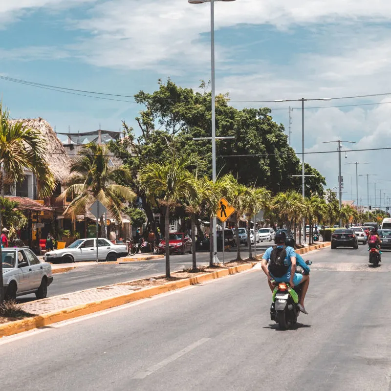 A street with a motorcycle in Tulum