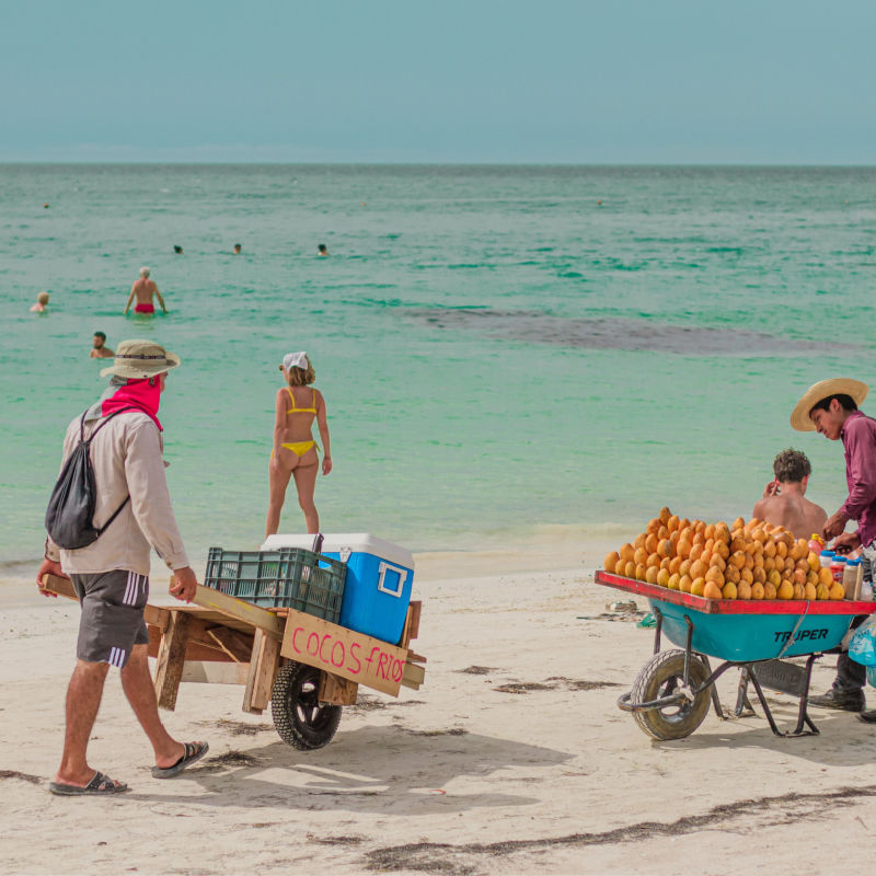 Travelers and vendors on a popular beach in Holbox