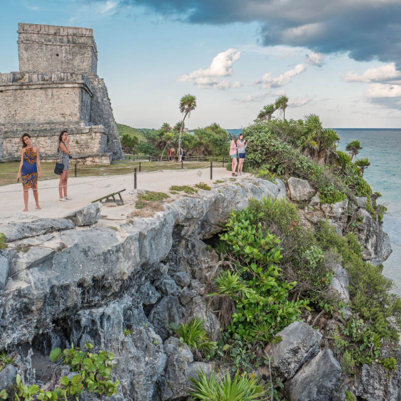 Travelers on top of a cliff in Tulum archeological  zone 