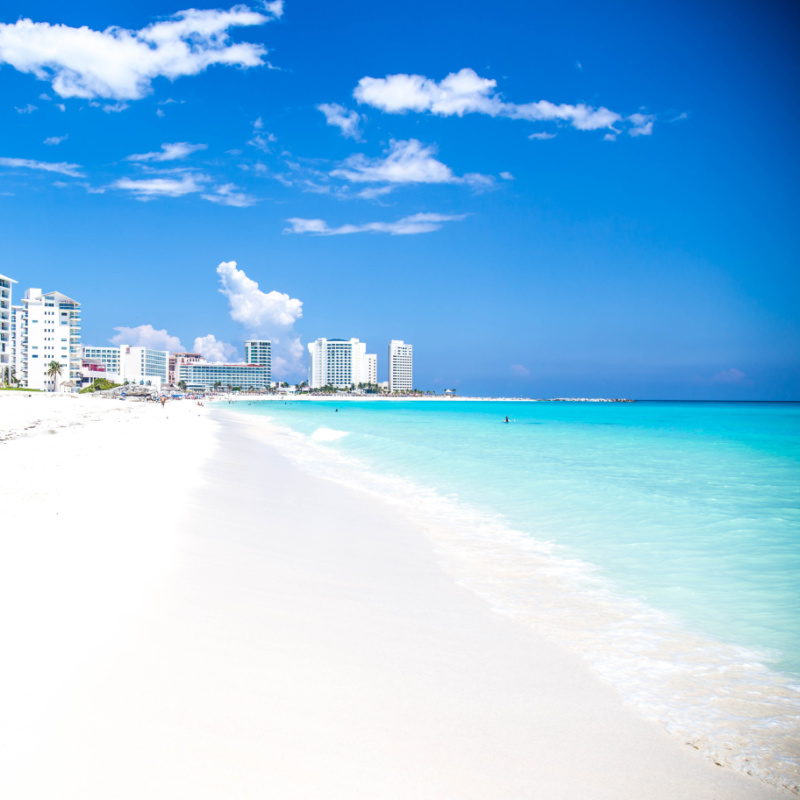 Pristine Beach in Cancun, Mexico with Resorts in the Background