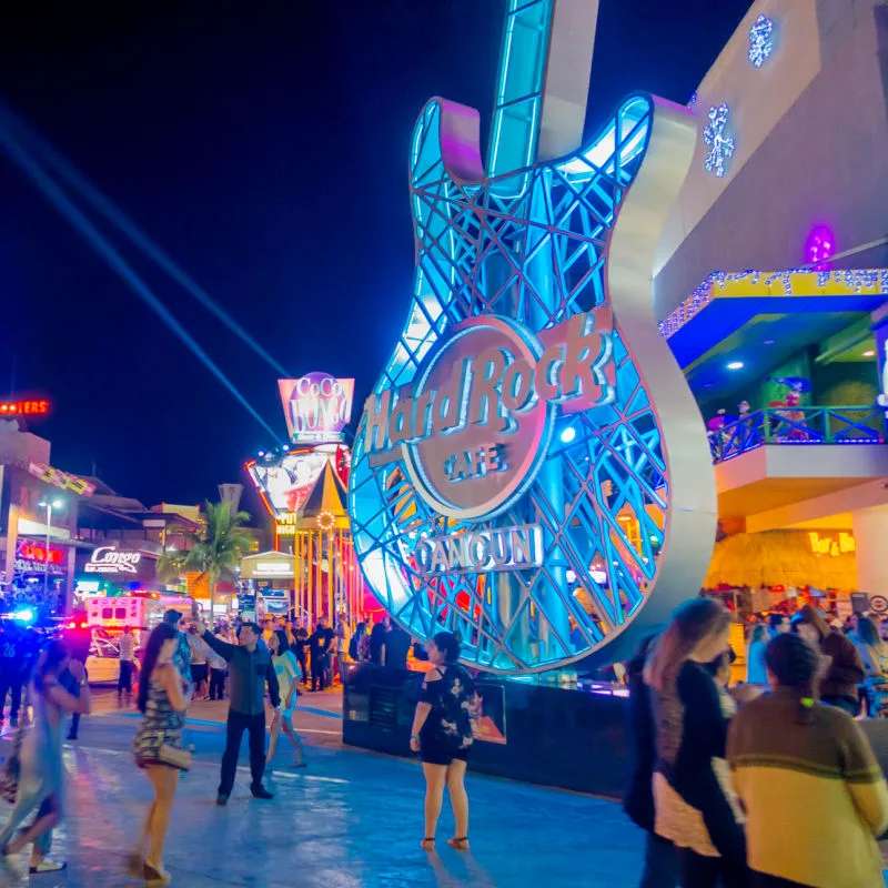 Los turistas caminan frente al Hard Rock Café en la zona hotelera de Cancún, México