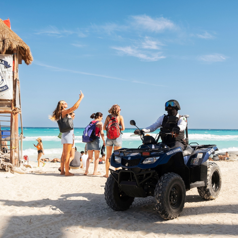 An armed officer on a vehicle in a Cancun beach 