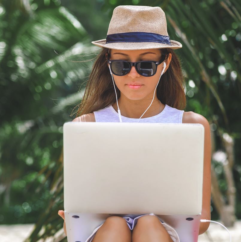Woman looking at laptop on beach