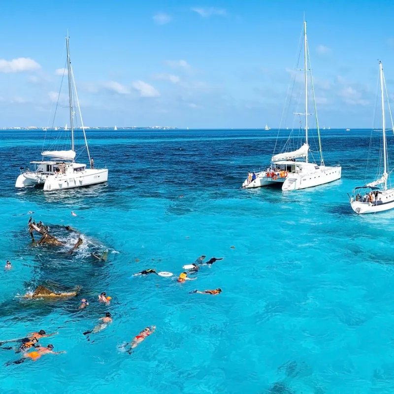 A catamaran tour with people diving in Cancun