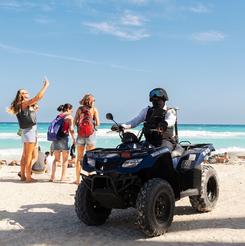 patrols on Cancun beach with tourists 