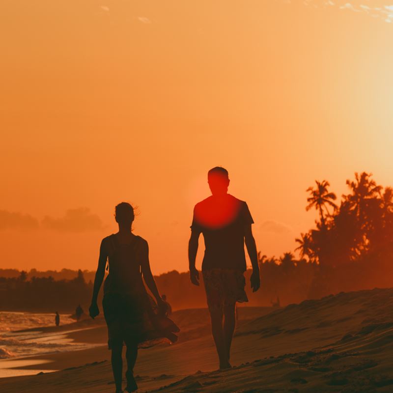 Couple walks on beach during sunset