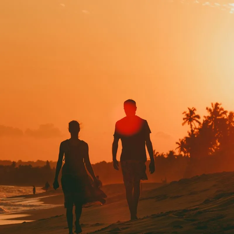 Couple walks on beach during sunset