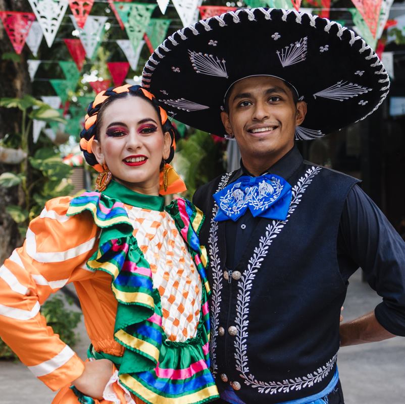 A mariachi and female dancer posing for a photo