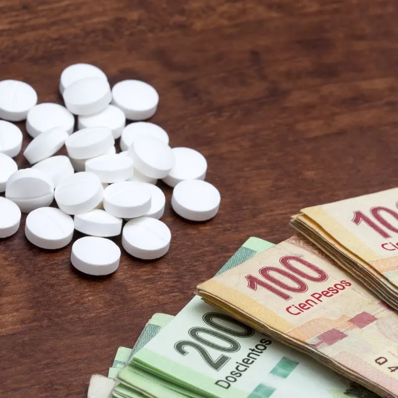 Medication and mexican pesos on a table