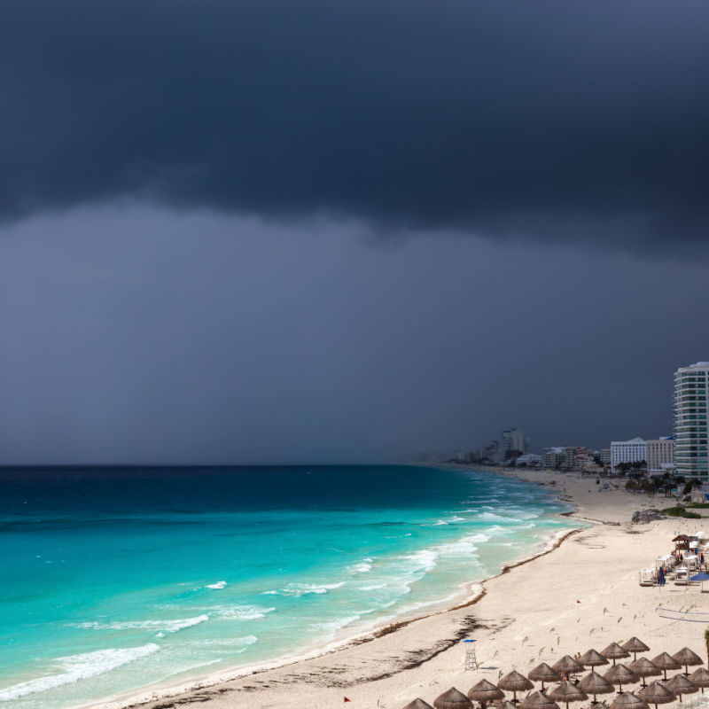 a stormy day on a cancun beach with dark clouds