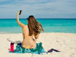 Woman on cancun beach with phone