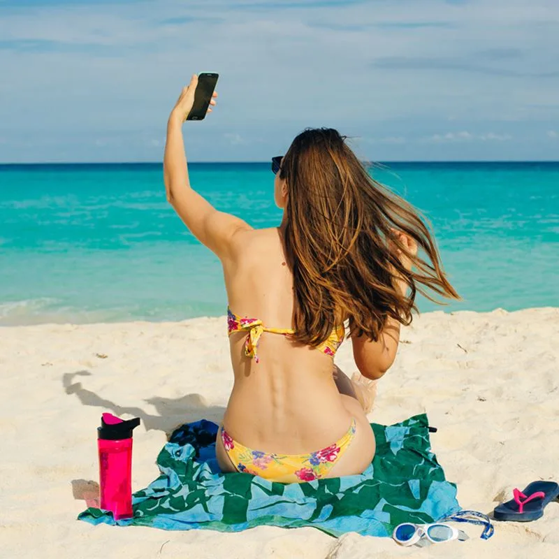 Woman on cancun beach with phone