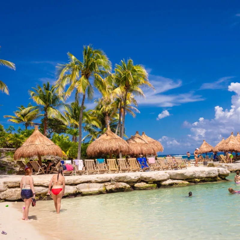 A small and clean seaside stone pier with sun loungers in Tulum