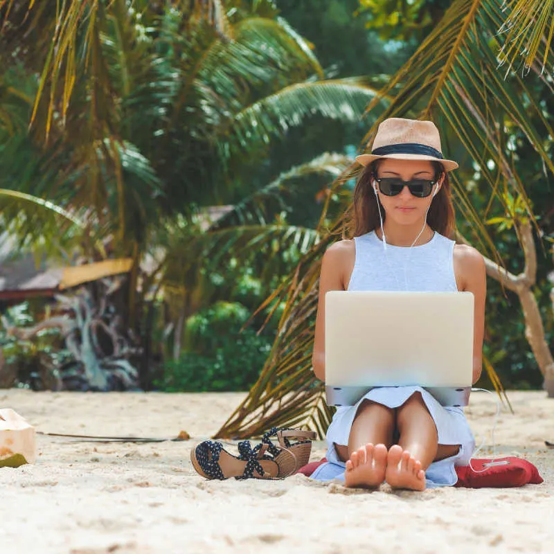 A digital nomad on a white sand beach in playa del carmen