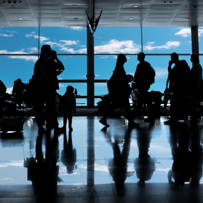 silhouettes of passengers at a busy airport