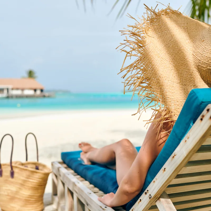 sunbather on Cancun beach with a sun hat